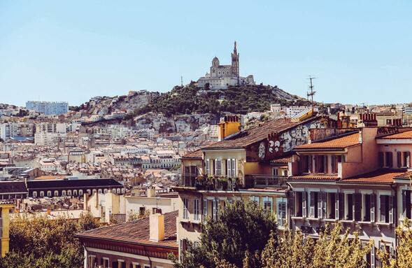 Basilique Notre Dame de la Garde en arrière-plan et un quartier de Marseille en avant-plan
